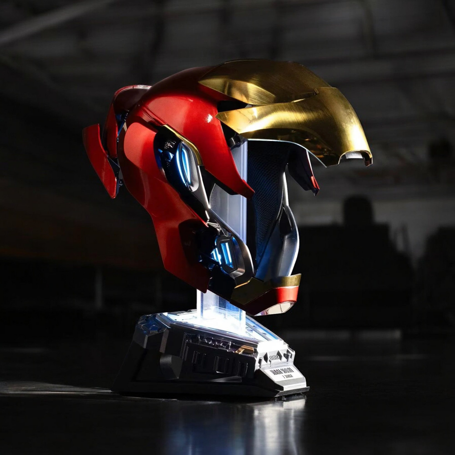 Iron Man MK50 Helmet on stand with dark industrial setting background.